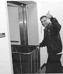Hector moving a laundry cart and giving the thumbs up sign